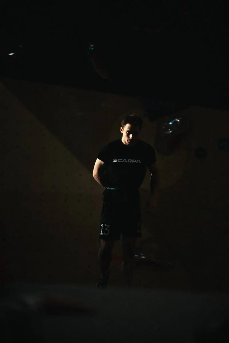 Trainer vor der Boulderwand